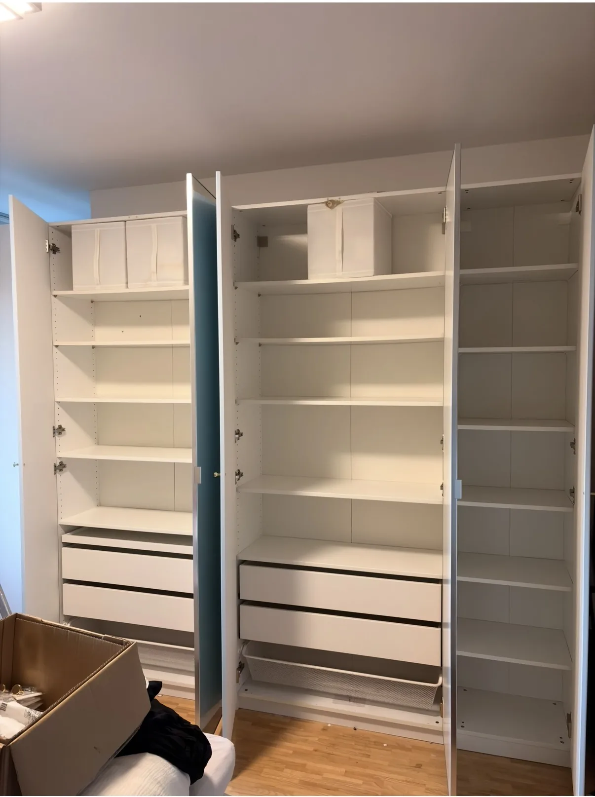 Weiße Schrankanlage mit Regalen und Schubladen